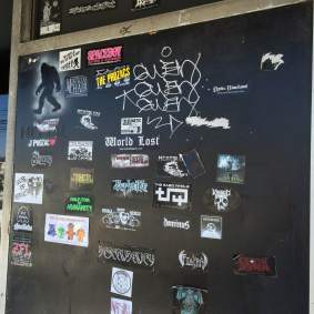 Stickers from some of the bands that have played here cover the stage entrance door.